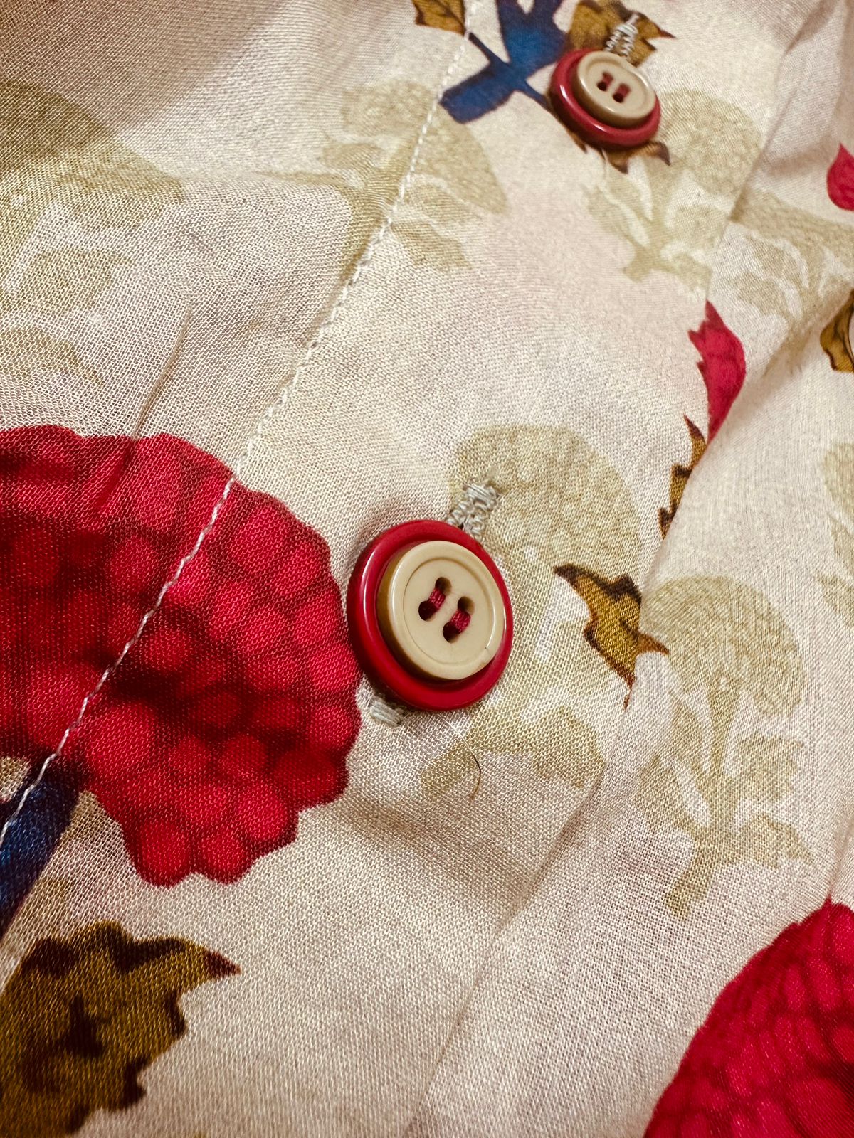 A vibrant marigold floral two-piece Pakistani suit, perfect for summer. Marigold Pakistani Top Close-up of buttons.